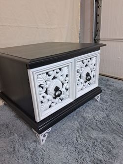 Refurbished black cofee table with white ornate designed.
