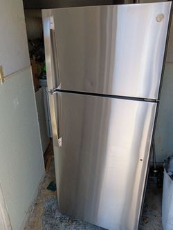 GE brand stainless steel apartment size refrigerator and top freezer