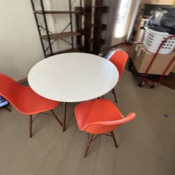 White Wood Circular Table With 4 Orange Chairs