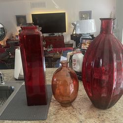 Three beautiful glass vases. 22H skinny vase. The Smaller Orange Vase 13H.    The larger vase 23H.  All (3) has some weight to it.