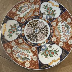 Japanese Imari porcelain plate, a style of Arita ware known for its vibrant colors and intricate designs. It features the characteristic underglaze bl