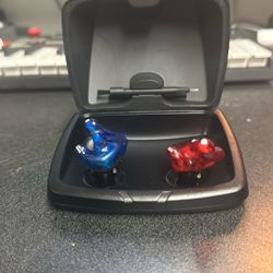 Starkey custom in-ear hearing aids along with their portable charging case. 