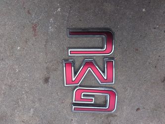 red and chrome GMC emblem badge likely for a truck grille or liftgate.
