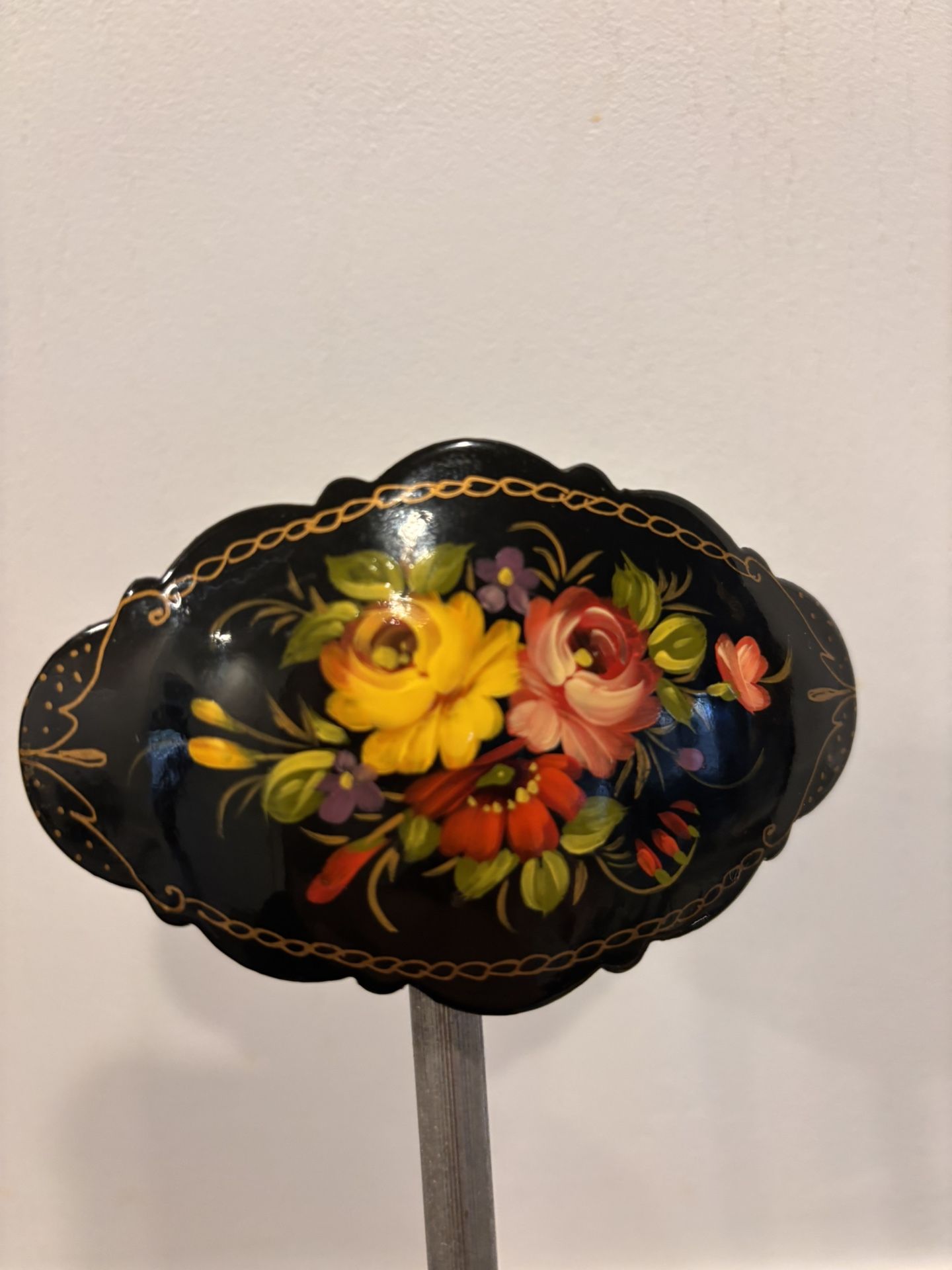 Russian hand-painted lacquer brooch featuring a floral design