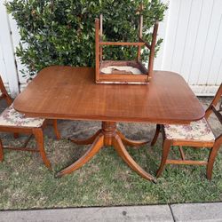 mahogany Duncan Phyfe-style single pedestal dining table with Chippendale-style ribbon-back chairs.
