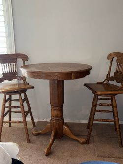 $450 OBO solid oak pub/game table set with two matching swivel bar stools