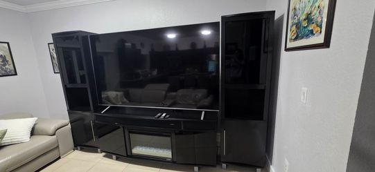 Black Entertainment Center with Electric Fireplace and Side Towers. Blue tooth speaker bass.