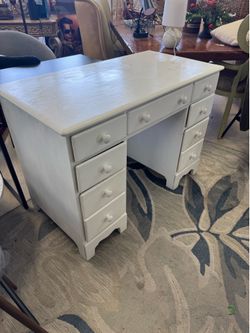 Painted white, solid wood desk featuring seven drawers and small wooden knobs - 42” x 22” x 89”