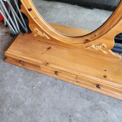 an oval, wood-framed dresser or vanity mirror