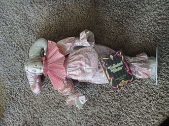 porcelain doll featuring a pink and iridescent outfit,