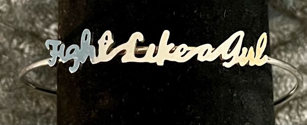 silver cursive script bracelet that spells out the empowering phrase, "Fight Like a Girl."