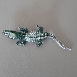 alligator-shaped brooch  with green and multicolored stones.