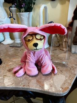 Plush dog in pink bunny costume