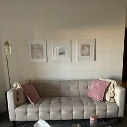 Tufted Beige Sofa With Wood Paneling