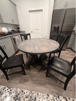 Weathered-look round dining table with 4 wooden chairs
