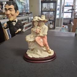 Dressed For A Special Occasion Young Couple Embracing Holding A Bouquet Of Flowers, In Heavy Intricately Carved Resin On A Wood Stand 6.5"H X 5"W