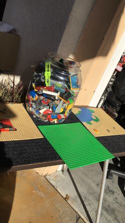 Plastic container full of Lego bricks and bases to build