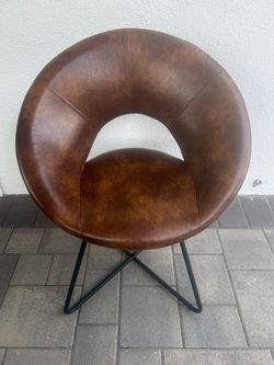 mid-century modern round accent chair in brown faux leather metal cross-leg