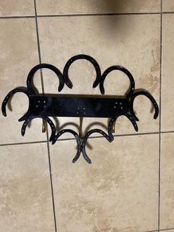 A rustic handmade horseshoe wall rack