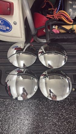 classic chrome "baby moon" or smooth domed center wheel hubcaps, featuring a highly polished reflective finish