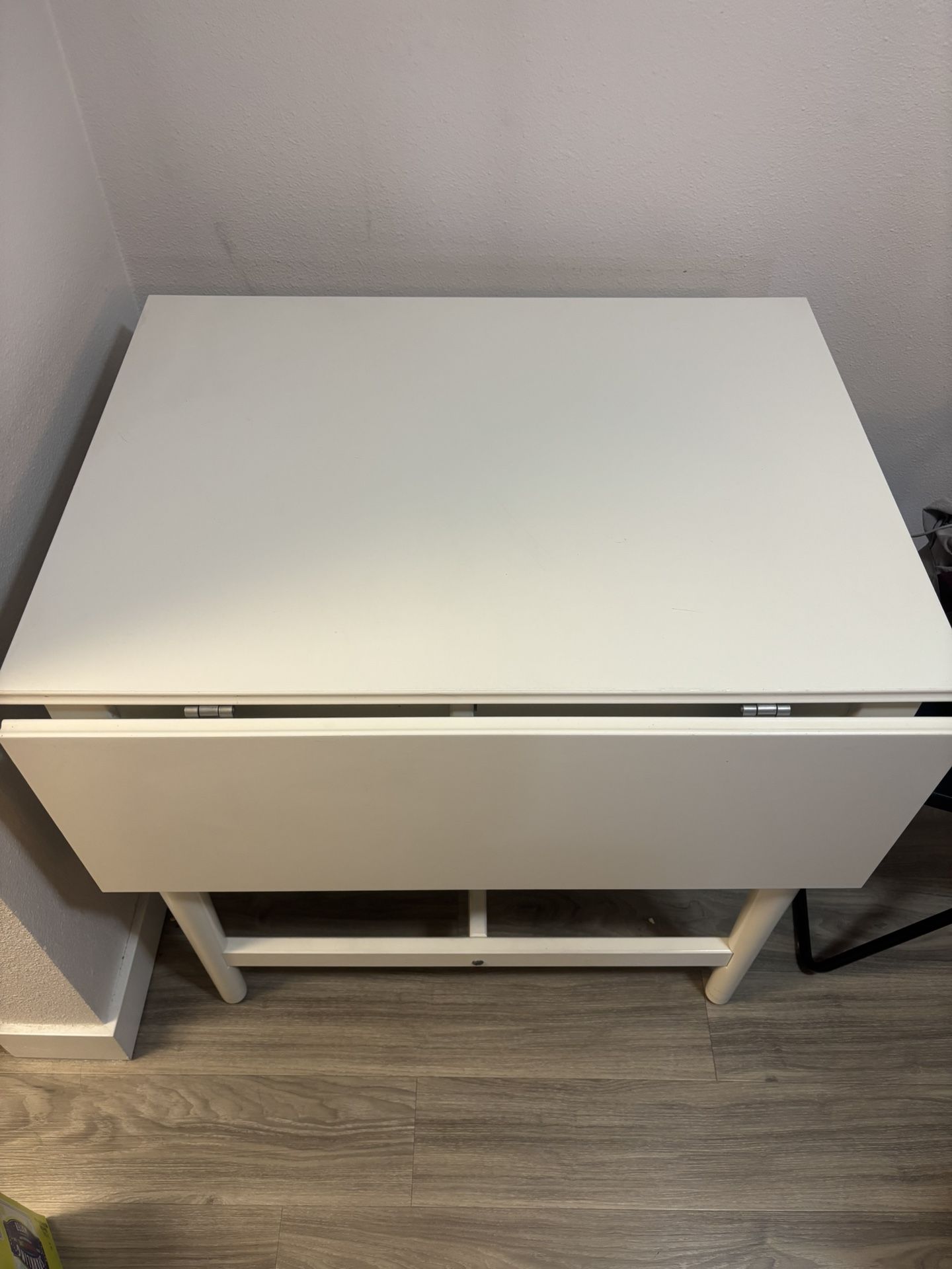 White wooden dining table with adjustable side leaves