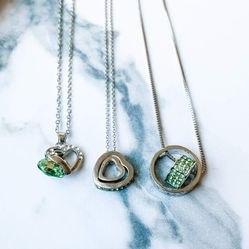 Three silver necklaces with green gemstones