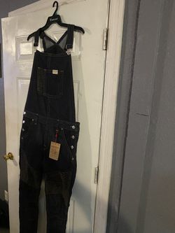 Dark blue denim overalls with front pocket and button details. $120 Location Mount Dora Fla 32757
