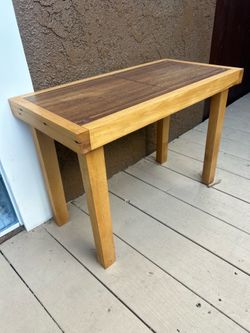 Handcrafted wooden console table with a two-tone brown and tan finish. Its L24”xW12”xH 17”. This piece has a solid wood construction with a dark wood 