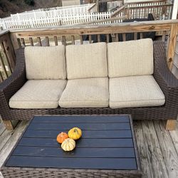 Raymour & Flanigan brown wicker outdoor sofa and table set.