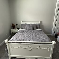 White full-size bed with night table