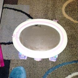 A Used Oval  Mirror, Pink, And White On Outer Part Of Mirrorppll No