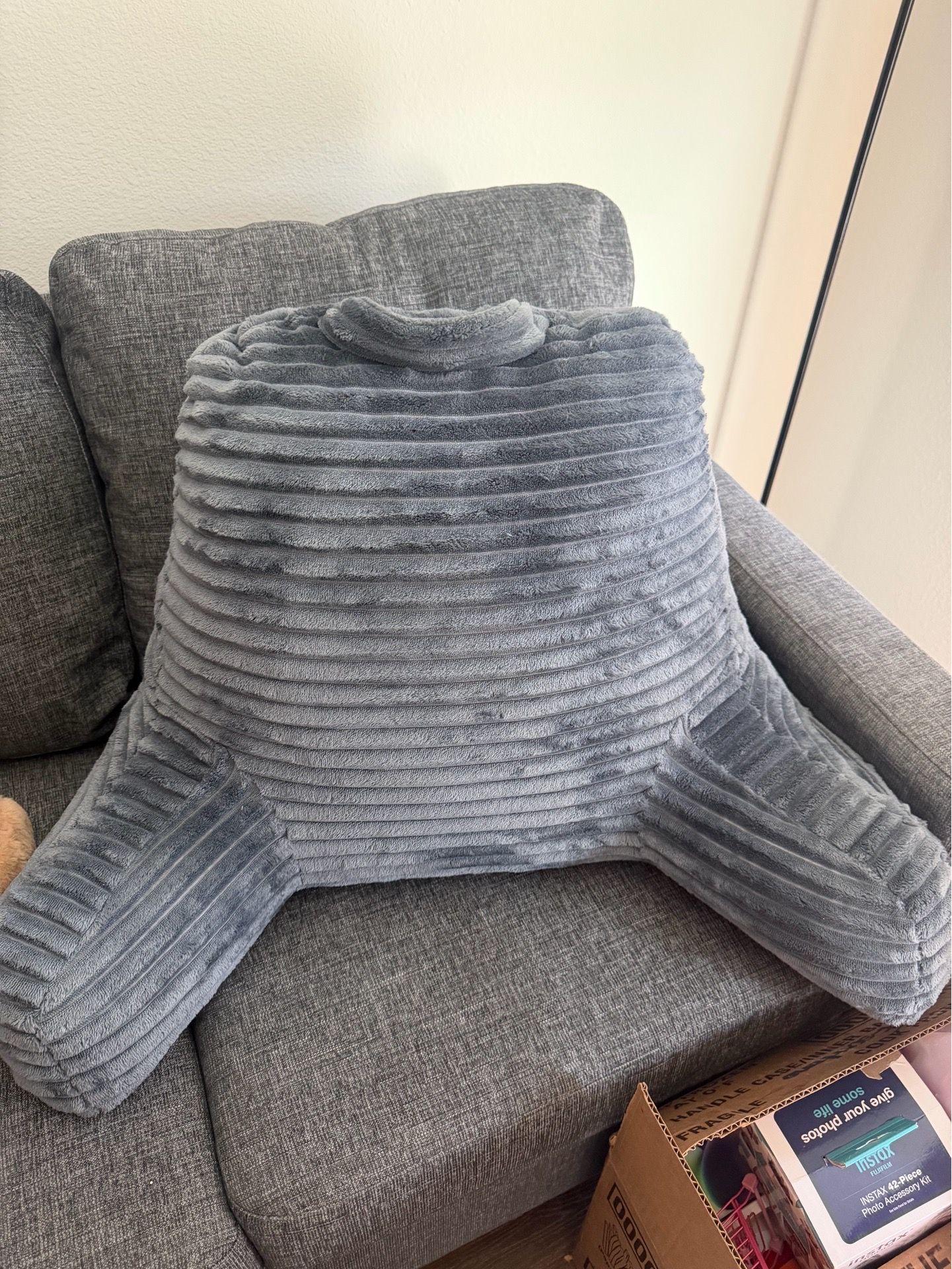 Nestl reading pillow with shredded memory foam and a striped plush cover in silver gray