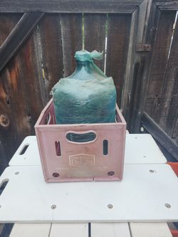 vintage 5-gallon blue glass water jug, likely from the 1960s or 1970s, commonly known as a demijohn.