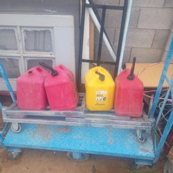 Four Five Gallon Gas Cans Three Of Them Have Legs One Of Them Missing A Lid