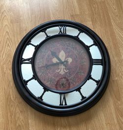 Round wall clock with Roman numerals and fleur-de-lis design. 22" Round, Use AA battery