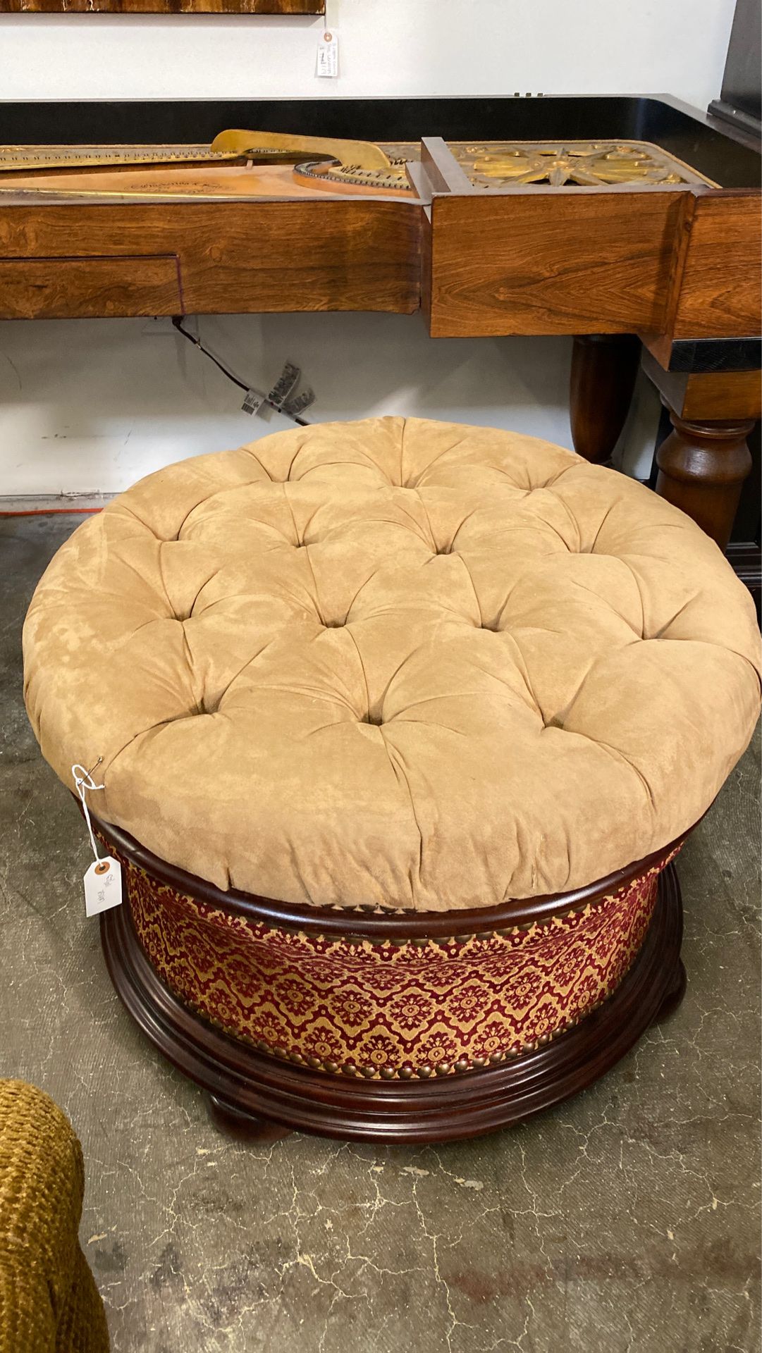 Round tan and red upholstered ottoman