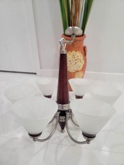 Ceiling chandelier. This 6-light fixture is the Empire model by Nuvo Lighting (reference 60-356), featuring a central wooden column with a reddish fin