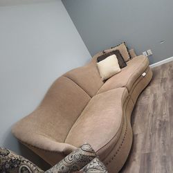 1 Over Sized Beige Sofa With Studs On Bottom 