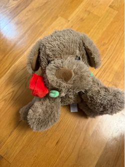 Puppy stuffed animal with rose in its mouth