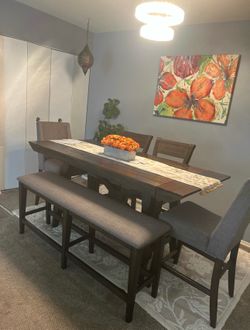 This 6 piece dining set dark wood table and bench with brown upholstered chairs.