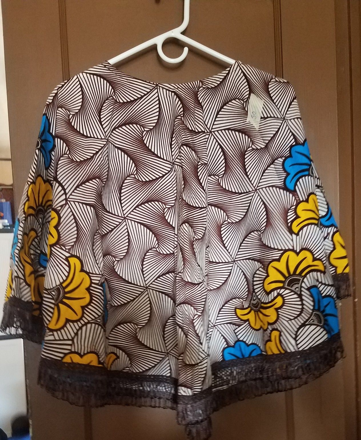 African fabric cape with fringes at the bottom. Medium to large can wear it.