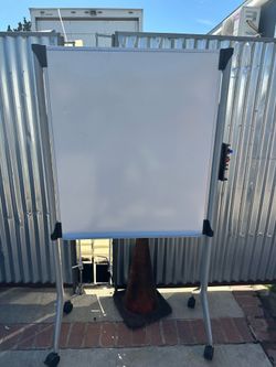 Versatile mobile whiteboard with a double-sided magnetic writing surface. It has a sturdy silver aluminum frame and a matching stand with four locking