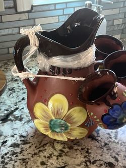 Pitcher harra with mugs.