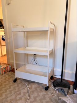 White metal bar cart with four wheels