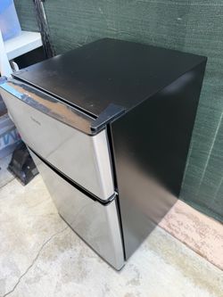 Galanz 3.1 Cu. Ft. Two-Door Mini Fridge in a stainless steel and black finish, featuring a separate top freezer compartment.