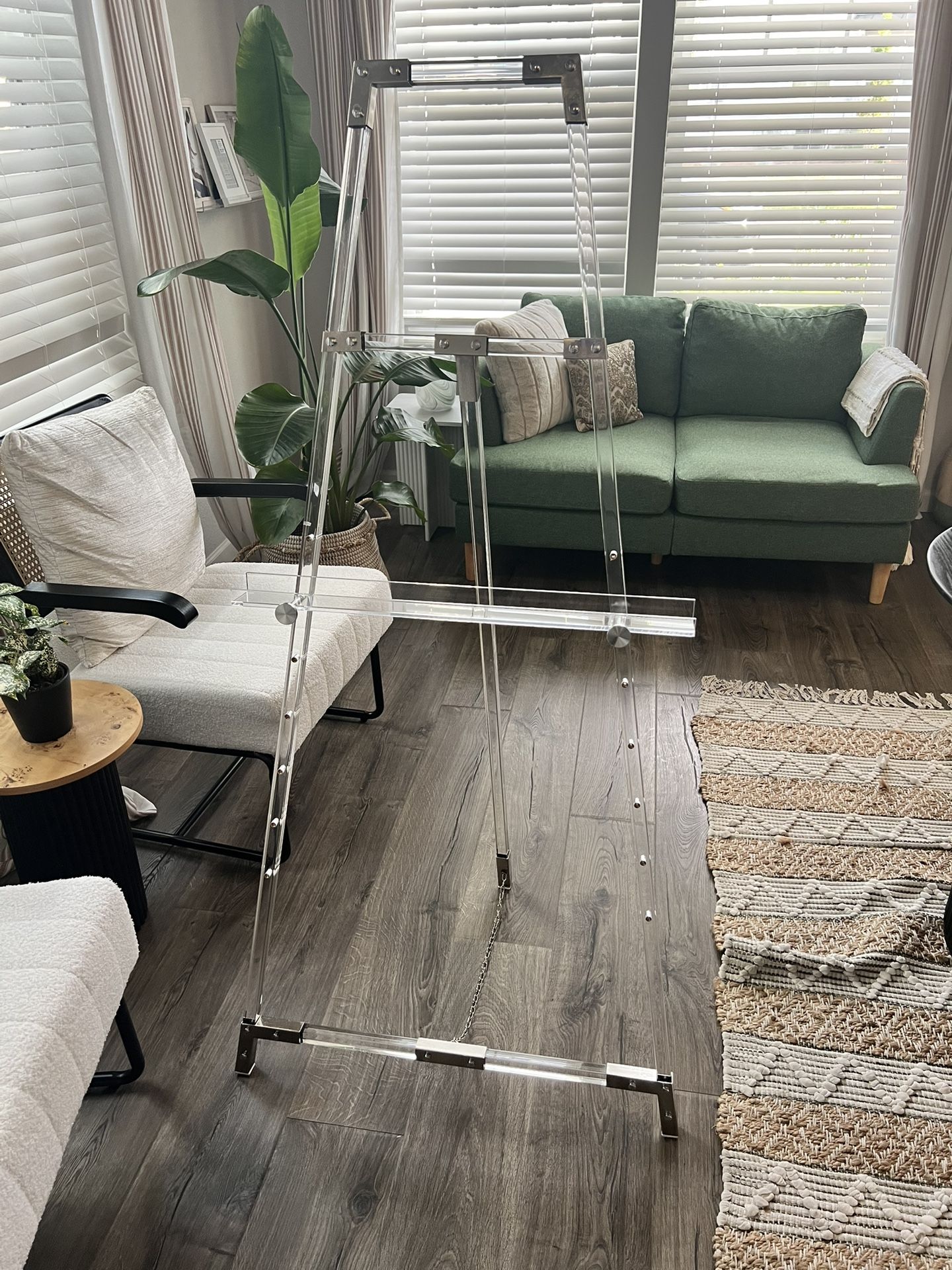 Clear acrylic plastic adjustable tier easel with silver accents and chain support.