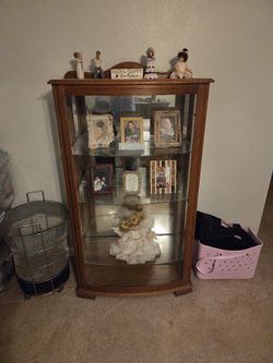 A WOOD CABINET WITH GLASS FRONT AND SIDE DOORS