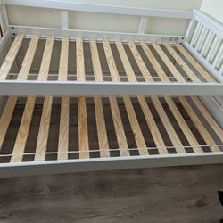 White wooden twin bed frame with twin trundle