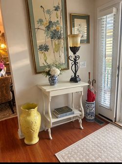 Charming accent table made from an antique sewing machine base with a distressed white finish, a drawer accessible from both sides and a lower display