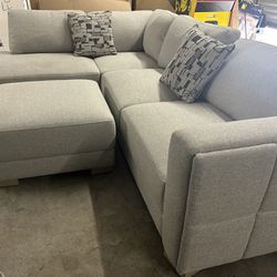 New Drayden Fabric Sectional with Ottoman  Retails for over $1,400  Features: Pocket Coil Seat Cushion Sinuous Spring Seat Support Solid Wood Legs Inc